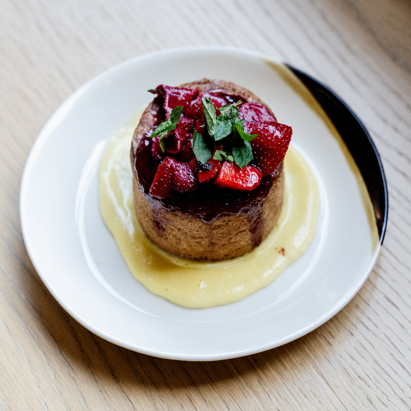 Dessert with a pastry topped with berries and cream on a Monsoon Pottery Small Coupe.