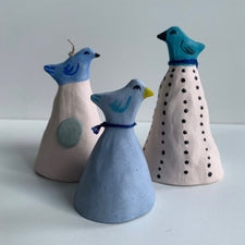 A set of three hand-painted porcelain bells with bird designs in blue color on each.
