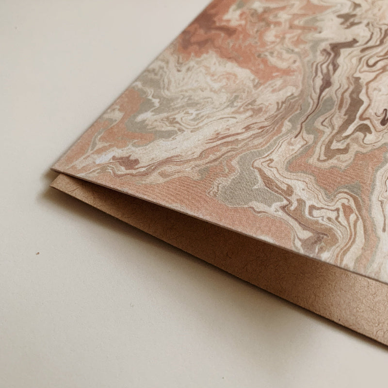 Marbled paper with a brown envelope on a light background