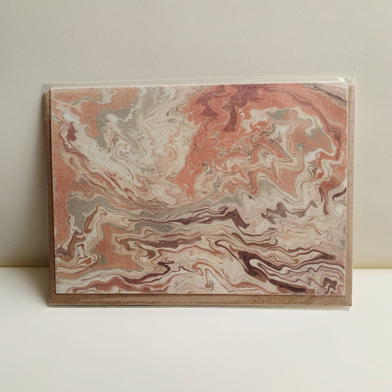 Marbled paper with pink and brown patterns on a white background