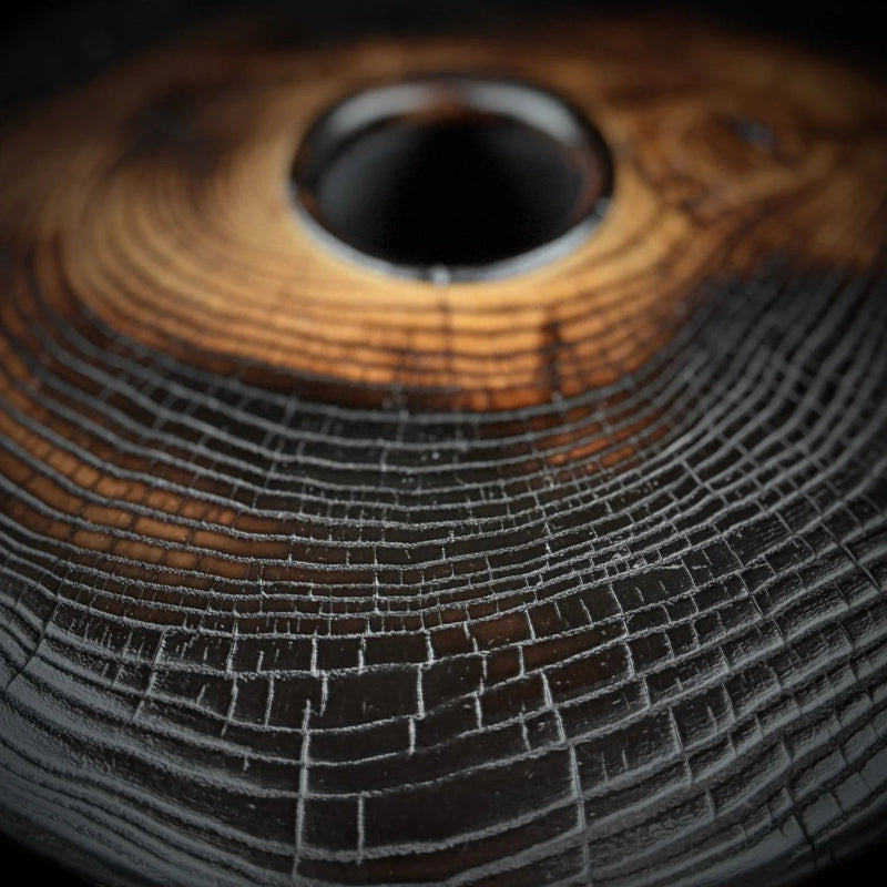 Close-up of a textured wooden bowl with concentric circular growth ring patterns.