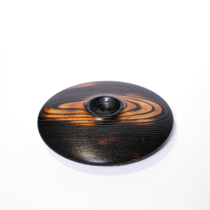 Charred ash wooden bowl with a central hole on a white background